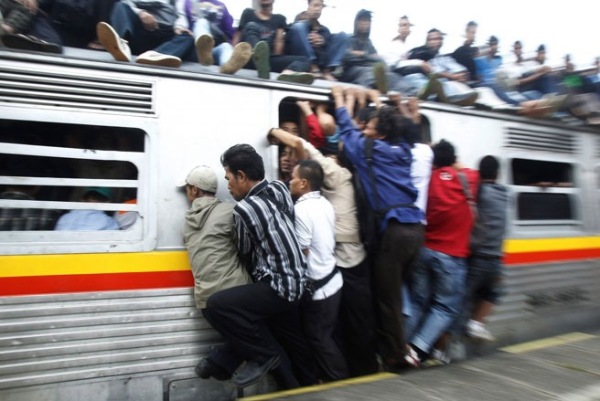 Những hành khách cố gắng bám vào một đoàn tàu ở tỉnh Tây Java của Indonesia - Ảnh: Reuters. 