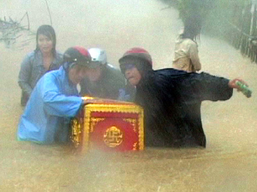 Gia đình 2 người bị chết do lốc xoáy ở Quảng Sơn, H.Quảng Trạch, Quảng Bình đưa quan tài người chết đi tránh lũ - Ảnh: Trường Giang